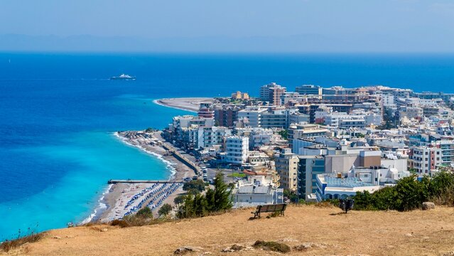 Rhodes, Greece - August 13, 2026: View of Paralia Elli beach on Rhodes Island, Greece, showing blue Aegean Sea, sandy and pebbled shoreline, and lively summer seaside atmosphere