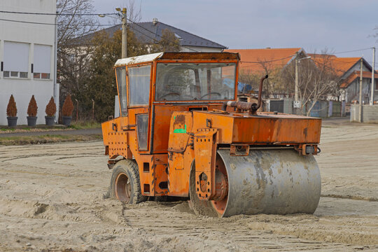 Old Equipment Smooth Steel Drum Roller Machine Compacting Sand at Construction Site