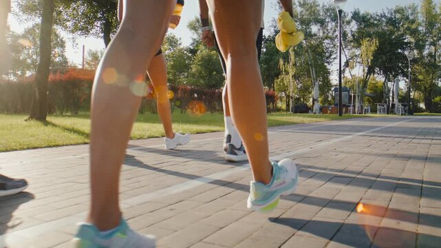 Athletes walk along park path after completing group running