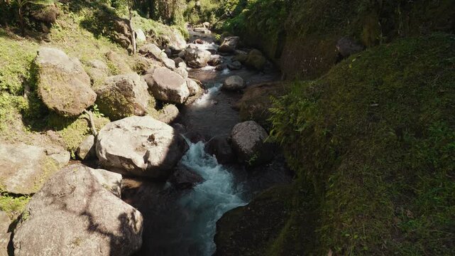 Rocky river stream flowing through the lush tropical landscape surrounding Gunung Kawi Temple in Tampaksiring Bali Indonesia