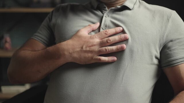 Man holding smartphone having sudden chest pain or heart attack
