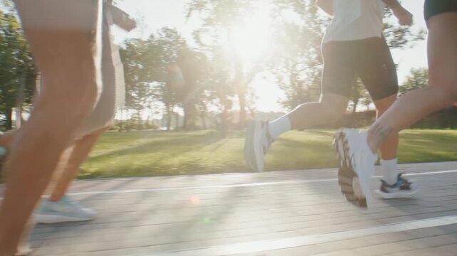 Group of runners trains with amputee athlete on sunny park path