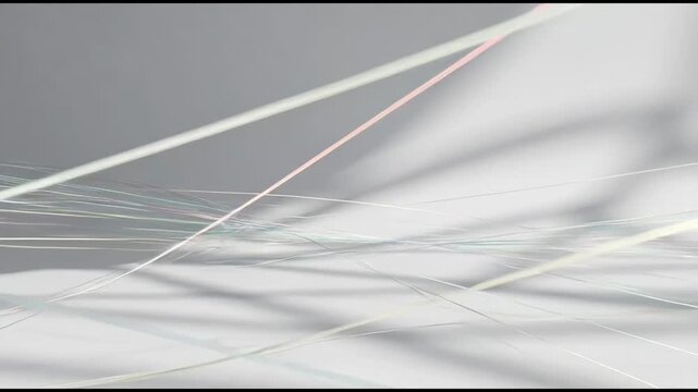 Thin intersecting light lines in abstract style on soft gray surface, concept of minimal motion and modern clarity
