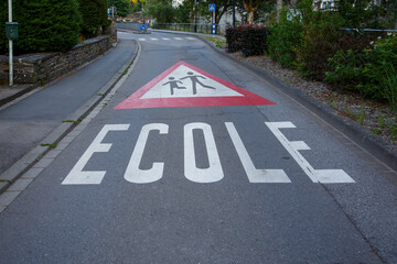 Obraz premium Translation: School. A longitudinal road warning sign indicating a school; it is typically painted on the road surface to mark the proximity of a school to the public roadway.