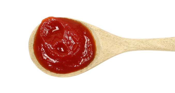 Tomato pulp in wooden spoon isolated on white background, top view