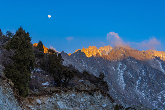 Majestic Mountain Range at Sunrise with Full Moon