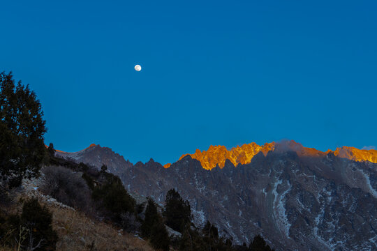Majestic Mountain Range at Sunrise with Full Moon in Kyrgyzstan