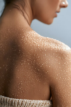 Water droplets glisten on wet shoulder skin near jaw macro
