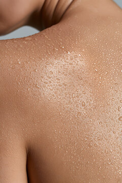 Water droplets bead on wet shoulder and neck skin macro