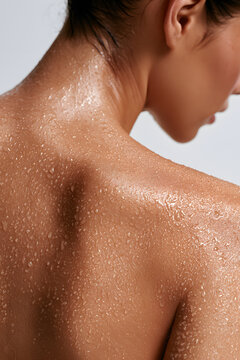 Water droplets bead on wet shoulder and neck skin light macro