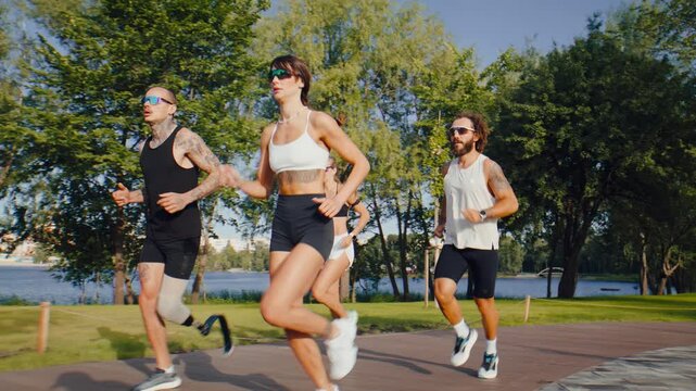 Group of athletes runs together through green park during workout