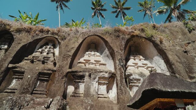 Massive ancient rock shrines carved into the cliffs at Gunung Kawi Temple in Tampaksiring Bali Indonesia