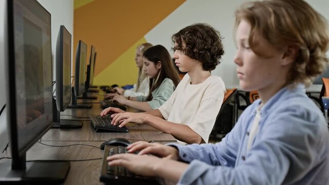 Caucasian teenagers typing on keyboards and studying on computers in school lab. Video is perfect for promoting STEM education, computer science programs and modern learning methods