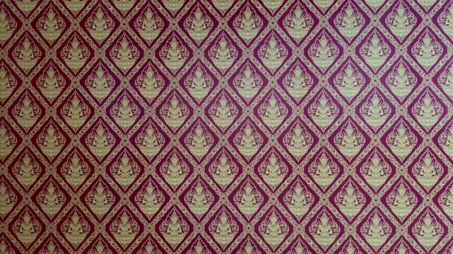 Static Shot of Traditional Thai Kanok Pattern with Golden Deity Motifs on Red Background.