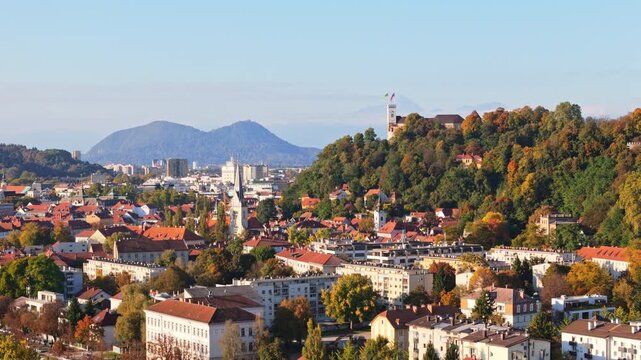 Ljubljana, the capital city of Slovenia, showcasing its buildings and green hills from a drone perspective.