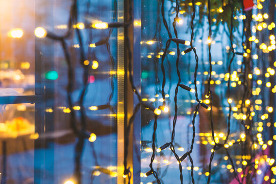 Festive lights glow against glass. Winter decoration adds warmth