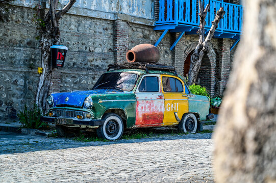 A colorfully painted Moskvich-407 car from the 1950s and 1960s with a kvevri clay jug on the roof rack and the inscription &ldquo;Sighnaghi,&rdquo; Kakheti, Sighnaghi, Georgia 12.04.2025