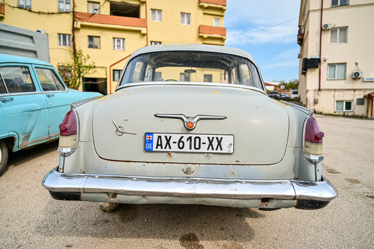 Gray historic GAZ-21 Volga classic car from the 1950s, in a parking lot in front of green hills near Shignaghi; Soviet classic cars, Georgia