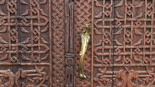 The carved wooden door in the traditional asian architecture style using elements of folk wood carving.