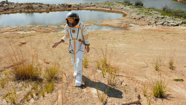 First steps of an explorer walking across the sandy terrain of an unknown planet