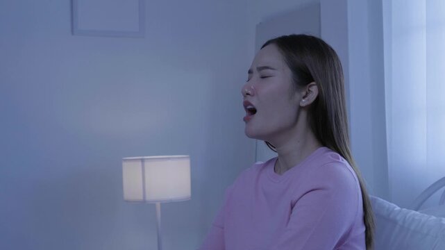 Sleepy woman yawning at night at home, showing tiredness and bedtime fatigue from lack of sleep, insomnia, yawning, sleepy, fatigue, tiredness