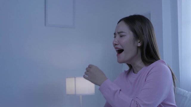 Sleepy woman yawning at night at home, showing tiredness and bedtime fatigue from lack of sleep, insomnia, yawning, sleepy, fatigue, tiredness