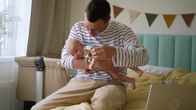 Remote programmer working on a laptop while holding a crying newborn baby, multitasking and attempting to soothe the infant while balancing professional and family life