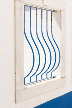 close up of curved blue railing against whitewashed window, minimal, architectural detail, negative space