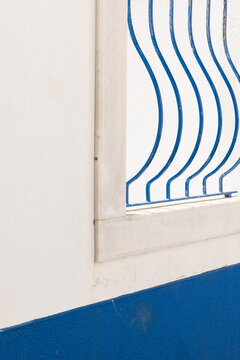 close up of curved blue railing against whitewashed window, minimal, architectural detail, negative space