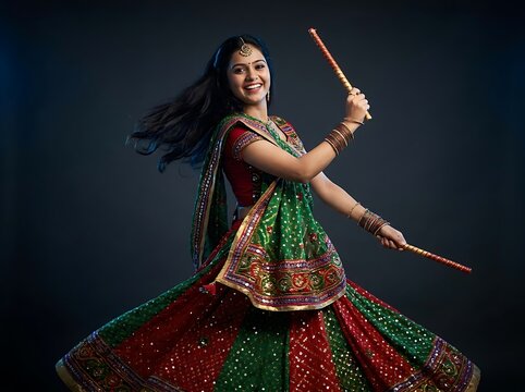 Young indian woman performing traditional garba dance with dandiya sticks