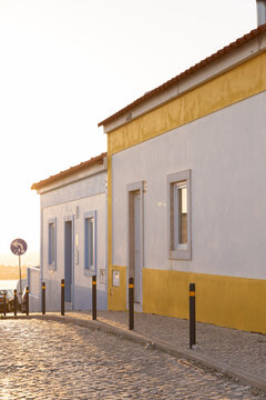 vertical shot of cobblestone street in Ericeira Portugal at golden hour looking towards ocean