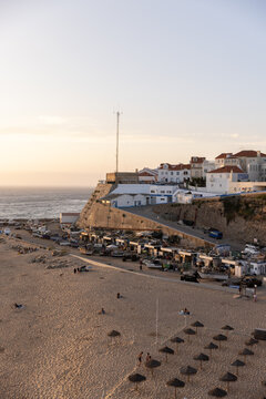golden hour sunset wide shot of Ericeira coast in Portugal with cliffs, ocean, and buildings