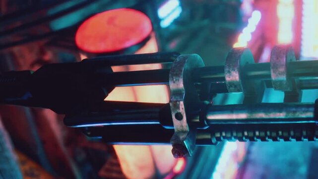 A machine part is shown up close, surrounded by colorful lights in a workshop setting. Various tools and equipment can be seen in the background.