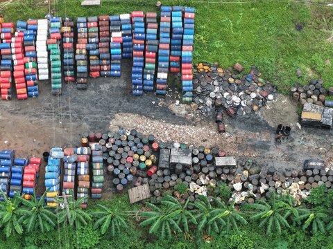 Aerial view of Gabtoli storage site with rows of colorful metal barrels, scattered drums, and surrounding greenery in Dhaka, Dhaka Division, Bangladesh.