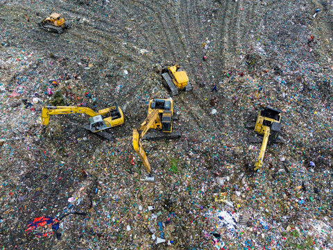 Aerial view of yellow excavators operating on large piles of waste at the Amin Bazar Waste Disposal Area Bongaon Union, Dhaka Division, Bangladesh.