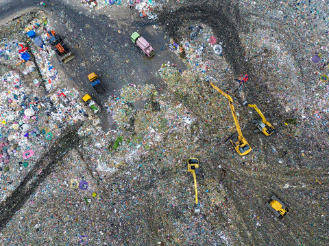 Aerial view of Amin Bazar Waste Disposal Area with heavy machinery and excavators operating on piles of waste in Bongaon Union, Dhaka Division, Bangladesh.