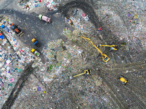 Aerial view of Amin Bazar Waste Disposal Area with excavators and trucks working on piles of waste, Bongaon Union, Dhaka Division, Bangladesh.