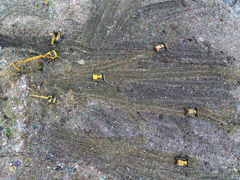 Aerial view of Amin Bazar Waste Disposal Area with yellow excavators and bulldozers working on the massive landfill in Bongaon Union, Dhaka Division, Bangladesh.