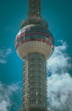 Aerial view of the iconic Oriental Pearl Tower featuring its distinctive spherical observation deck and antenna mast against a bright blue sky in Shanghai, Shanghai, China.