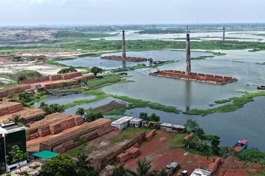 Aerial view of Gabtoli brick kilns surrounded by flooded fields with stacks of red bricks and green vegetation in Dhaka, Dhaka Division, Bangladesh.