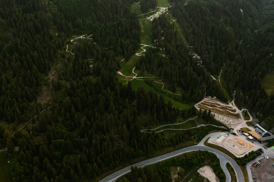 Aerial view of mountain bike trails winding through dense pine forests and alpine meadows in the resort area of Fiss, Tyrol, Austria.