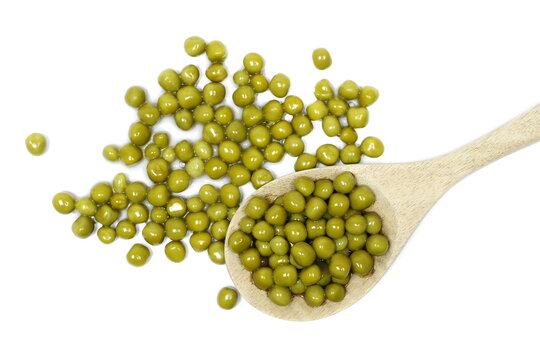 Boiled green peas pile in wooden spoon isolated on white background, top view