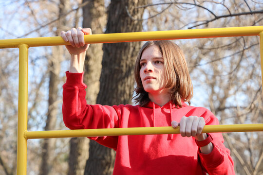Youth Training Perseverance. Young Athlete Maintains Intense Focus While Performing Outdoor Exercises In Park Setting