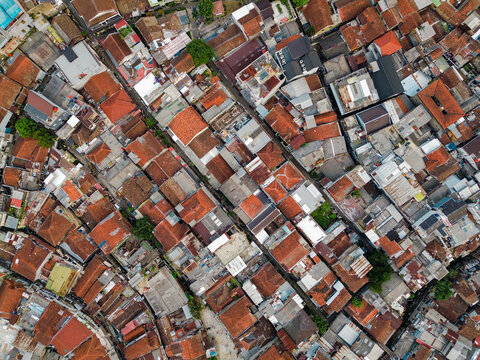 Aerial view of a dense urban neighborhood featuring terracotta rooftops, narrow streets, and residential buildings in Bandung, West Java, Indonesia.