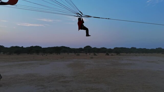 Paraglider preparing for takeoff across the Thar Desert near Khuri, Jaisalmer, Rajasthan, India