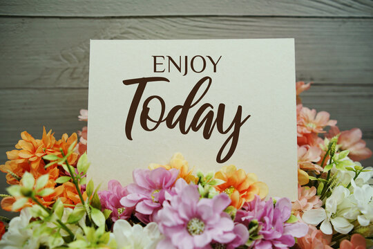 Enjoy Today text written on paper card with flowers decorations