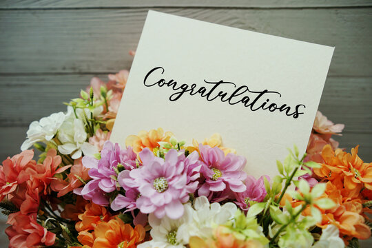 Congratulations text written on paper card with flowers decorations