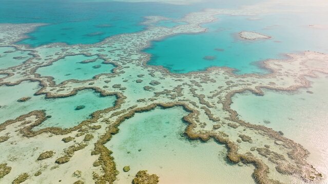 Aerial view of turquoise coral reef and shallow lagoons for travel, conservation and editorial use