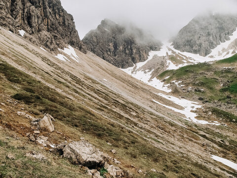 Dramatic alpine panorama from the Mindelheim Via Ferrata in the Allgaeu Alps, Germany, partially snow covered mountain slopes and rugged peaks emerging through clouds, cinematic adventure travel lands
