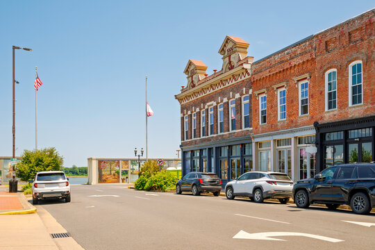 Distinctive 19th century red brick buildings along historic downtown Broadway street, with the Floodwall Murals gallery along the Ohio River in Paducah, Kentucky.